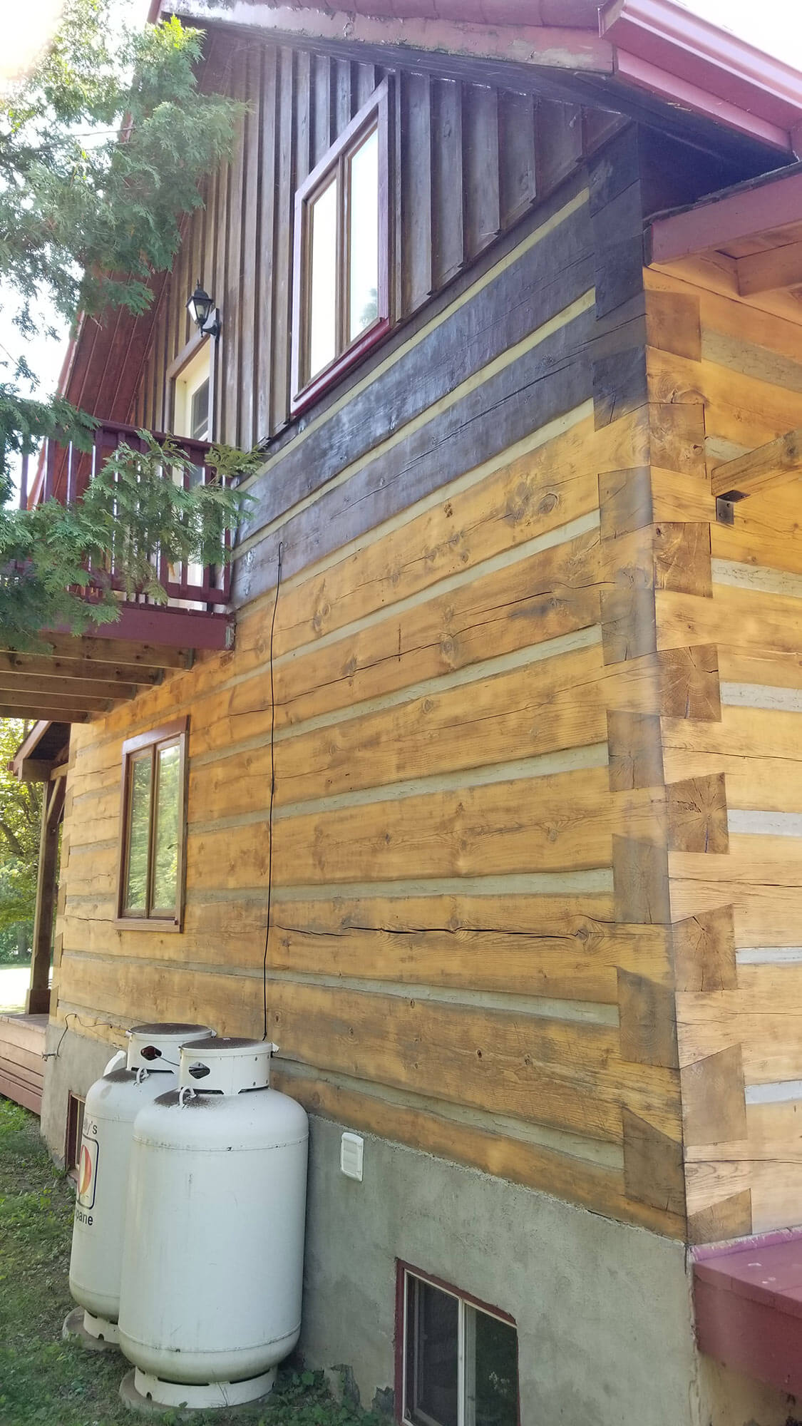 Restored log home exterior in a wooded setting